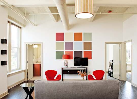 a living room with red chairs and a couch at 100 South Apartments, New York