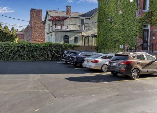 a parking lot filled with cars in front of a building at The Granite Works Apartments , New York 14202