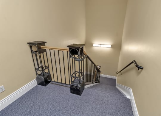 the upstairs landing of a home with a stairwell and a railing and a staircase at The Granite Works Apartments , Buffalo, NY, 14202