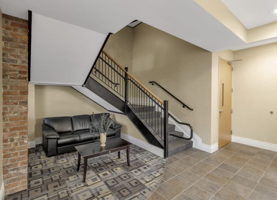 a living room with a couch and a staircase at The Granite Works Apartments , New York