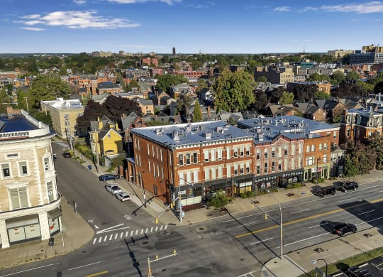 an aerial view of a building with a blue roof on a city street at The Granite Works Apartments , Buffalo