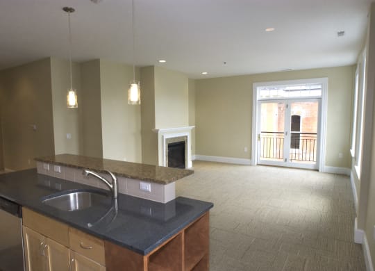 an empty kitchen and living room with a fireplace at The Granite Works Apartments , Buffalo, New York