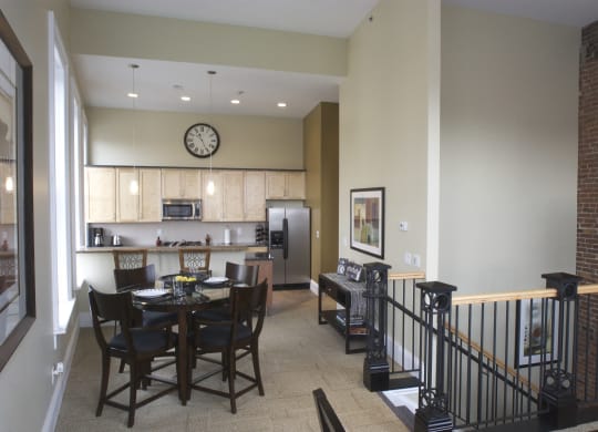 a dining room with a table and chairs and a kitchen at The Granite Works Apartments , Buffalo, NY