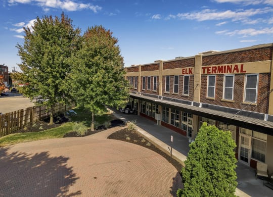 an aerial view of a building with trees and a sidewalk at The Lofts at Elk Terminal, Buffalo, 14204
