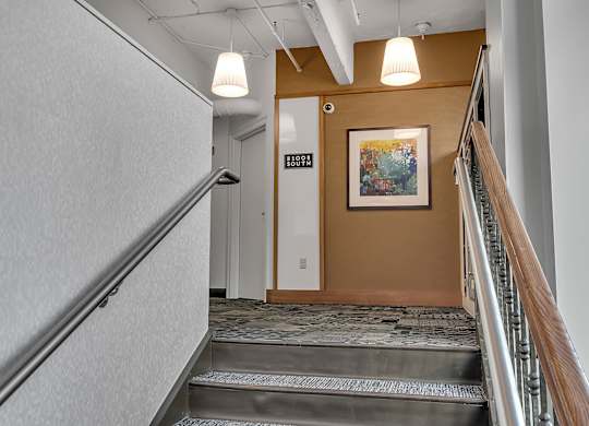 a view of a lobby with stairs and a painting on the wall at 100 South Apartments, Buffalo, New York