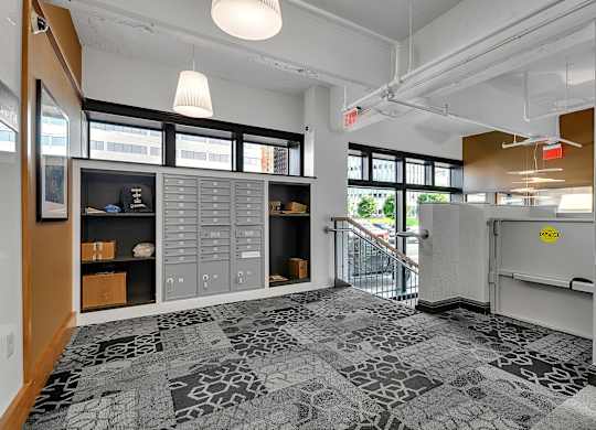the lobby of a building with a reception desk and a door to a staircase at 100 South Apartments, Buffalo, NY