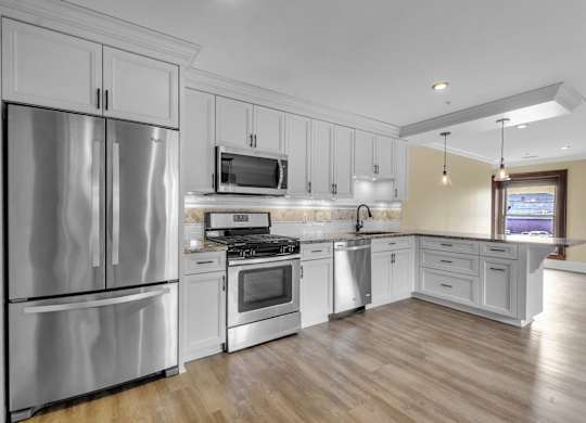 a kitchen with stainless steel appliances and white cabinets at The Knights @ 506 Delaware Apartments, New York