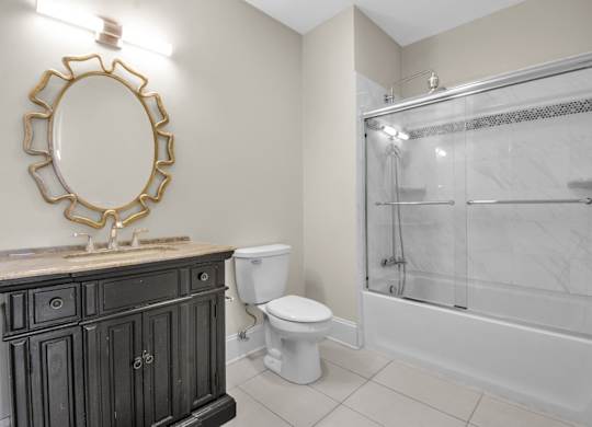 A bathroom with a toilet, sink, and shower at The Knights @ 506 Delaware Apartments, Buffalo, New York