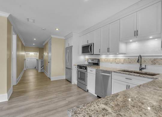 A kitchen with granite countertops and stainless steel appliances at The Knights @ 506 Delaware Apartments, Buffalo