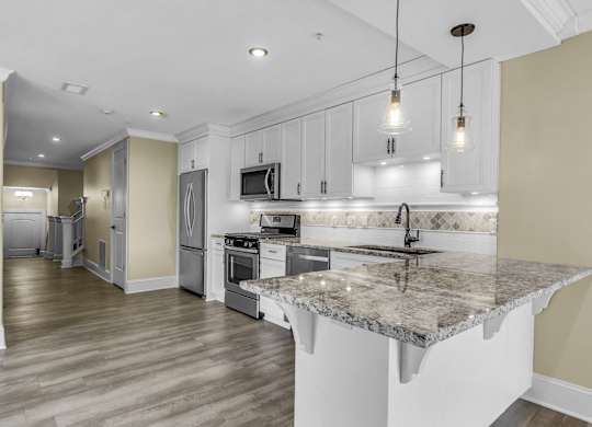 A kitchen with a granite countertop and stainless steel appliances. at The Knights @ 506 Delaware Apartments, Buffalo, NY