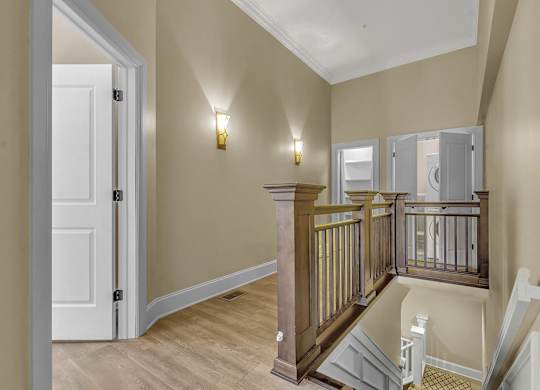 the landing of a staircase in a home with a door to a hallway at The Knights @ 506 Delaware Apartments, Buffalo, NY