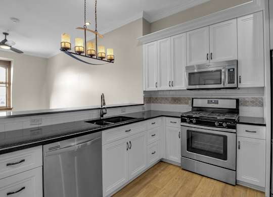 a kitchen with stainless steel appliances and white cabinets at The Knights @ 506 Delaware Apartments, Buffalo, NY 14202