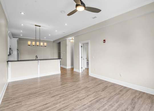 an empty living room with a ceiling fan and a kitchen at The Knights @ 506 Delaware Apartments, New York, 14202