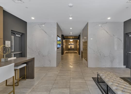 a long hallway with marble walls and a lobby with chairs and tables at Nineteen North, Buffalo, New York