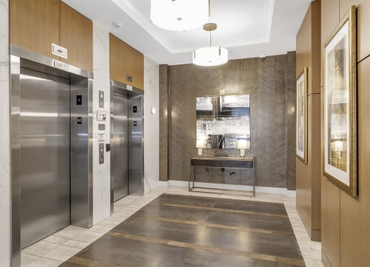 a lobby with stainless steel refrigerators and elevators and a marble floor at Nineteen North, New York