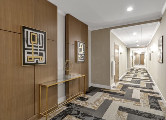 a long hallway with a carpet of geometric tiles and wood paneling at Nineteen North, Buffalo, 14202