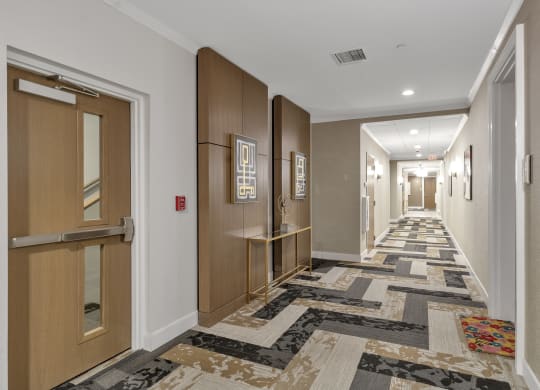 a long hallway with doors and carpeted floors at Nineteen North, Buffalo, 14202