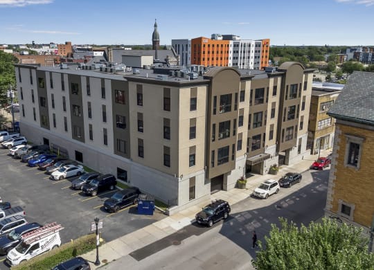 an aerial view of an apartment building with a parking lot and cars parked at Nineteen North, New York, 14202