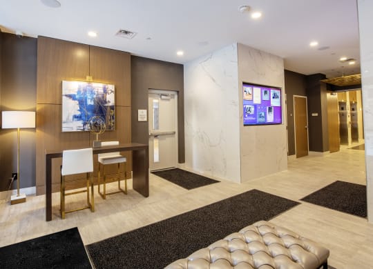 a lobby with a table and chairs and a television at Nineteen North, Buffalo, New York