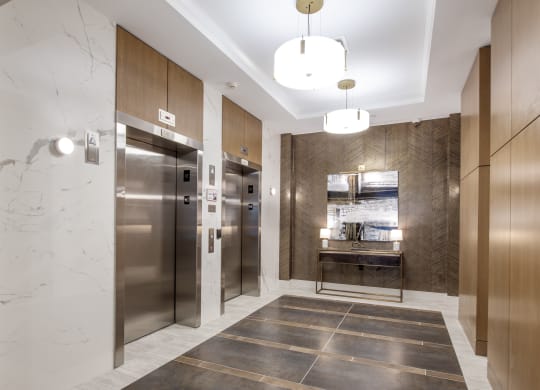a lobby with stainless steel refrigerators and elevators and marble floors at Nineteen North, New York, 14202