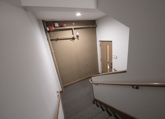 a stairwell with a railing and a door to a room with a brown wall at Nineteen North, New York, 14202