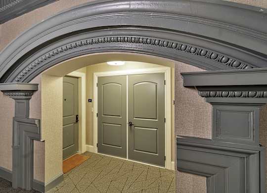 an empty hallway with an archway and two doors at The Knights @ 506 Delaware Apartments, Buffalo, NY 14202