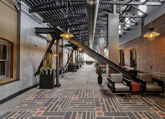 a lobby with a large staircase and a rug on the floor at The Knights @ 506 Delaware Apartments, New York