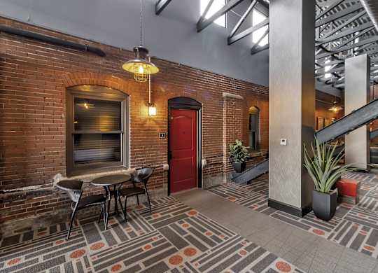 the lobby of a building with a red door and a table and chairs at The Knights @ 506 Delaware Apartments, Buffalo, New York