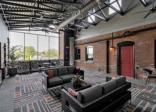 a living room with couches and a red door at The Knights @ 506 Delaware Apartments, Buffalo, NY