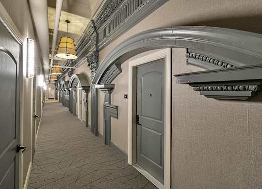 a hallway with white doors and a ceiling with a light fixture at The Knights @ 506 Delaware Apartments, Buffalo