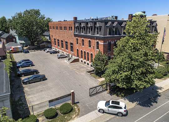 an aerial view of a brick building in a parking lot at The Knights @ 506 Delaware Apartments, New York