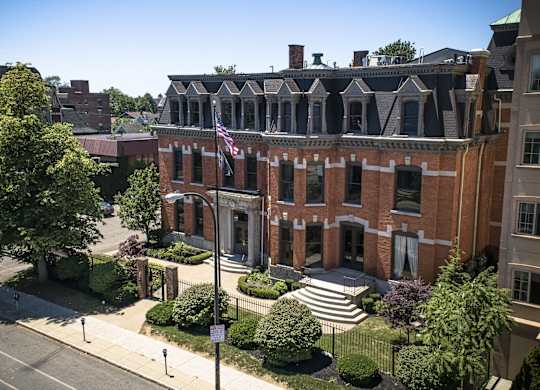 an aerial view of a red brick building with an flag at The Knights @ 506 Delaware Apartments, Buffalo, NY