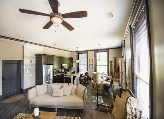 a living room and kitchen with a couch and a ceiling fan at The Knights @ 506 Delaware Apartments, New York