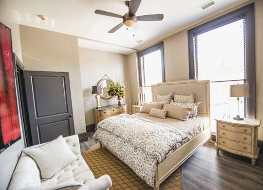 a bedroom with a bed and a ceiling fan at The Knights @ 506 Delaware Apartments, Buffalo, New York