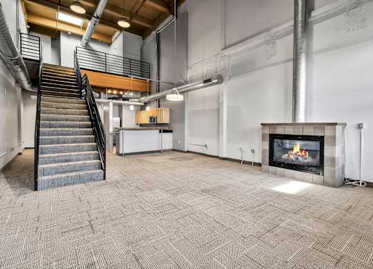 Two story loft with staircase and fireplace at The Lofts at Elk Terminal Apartments, Buffalo