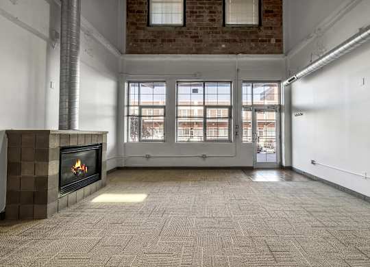 Loft living room with fireplace and large windows at The Lofts at Elk Terminal Apartments, New York, 14204