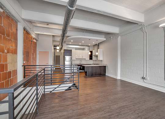 Upper floor loft area with exposed ductwork and railings at The Lofts at Elk Terminal Apartments, Buffalo, 14204