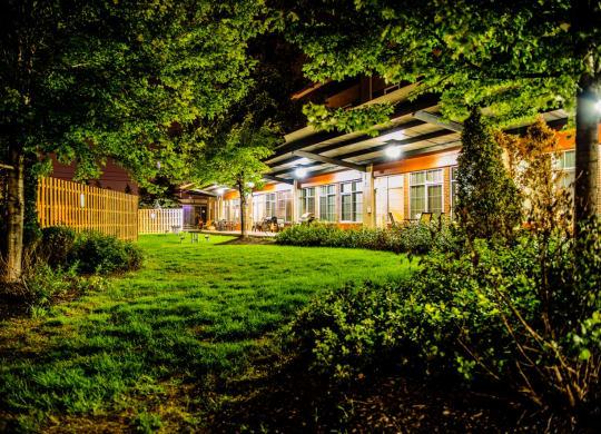 a backyard at night with lush green grass and trees at The Lofts at Elk Terminal, Buffalo, NY, New York