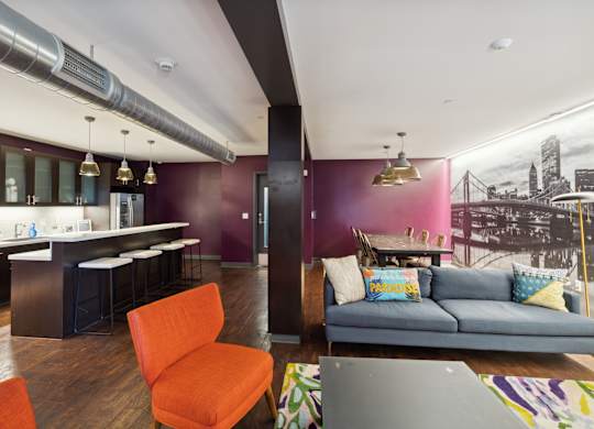 A living room with a couch, chair, and a kitchen area. at Walnut on Highland, Pittsburgh, PA