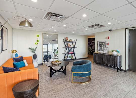 A living room with a sofa, a coffee table, and a bookshelf at Walnut Towers at Frick Park, Pittsburgh, PA 15217