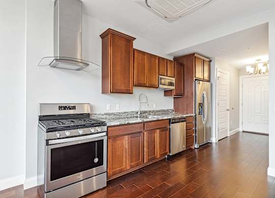 A kitchen with wooden cabinets and stainless steel appliances. at The Washington at Chatham, Pennsylvania, 15219