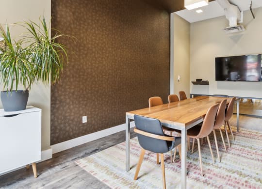 a conference room with a long wooden table and chairs and a television at Bakery Living, Pittsburgh, PA