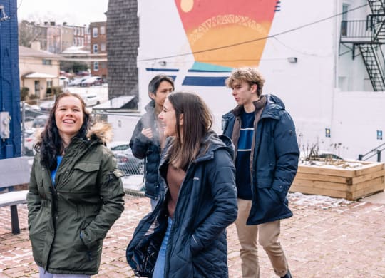 a group of people standing in front of a building at University Commons Apartments, Oakland, Pittsburgh