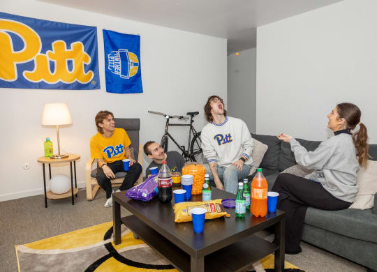 a group of people sitting around a coffee table at University Commons Apartments, Oakland, Pittsburgh