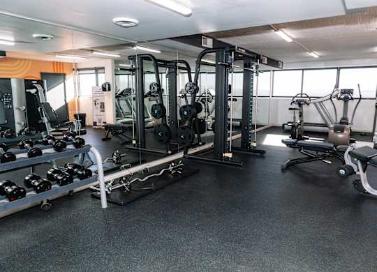 A gym with a variety of equipment including weights and weight machines at Walnut Towers at Frick Park, Pennsylvania
