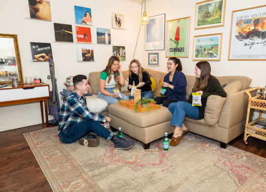 a group of people sitting on a couch in a living room at University Commons Apartments, Oakland, Pittsburgh