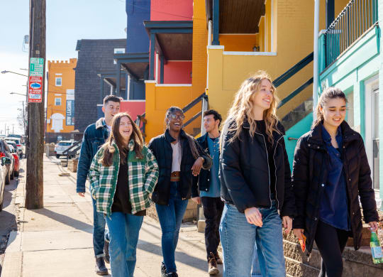 a group of young people walking down a street at University Commons Apartments, Oakland, Pittsburgh