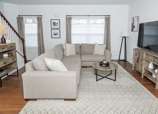 A living room with a couch, a coffee table, and a television. at Highland Village, Ross Township, Pittsburgh, PA 15229