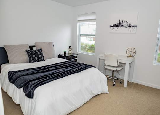 A bedroom with a large bed and a desk. at Highland Village, Ross Township, Pittsburgh, PA 15229