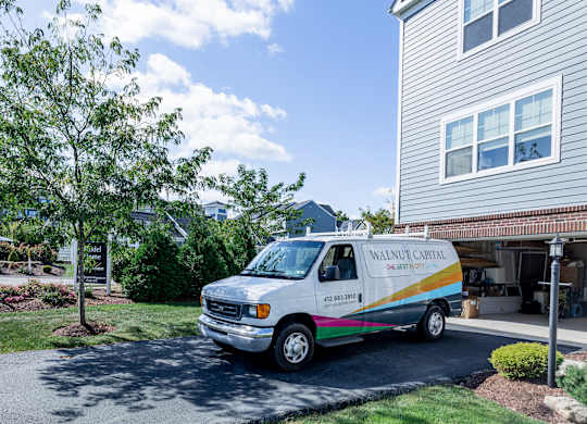 A white van with a rainbow stripe is parked in front of a house. at Highland Village, Ross Township, Pittsburgh, PA 15229